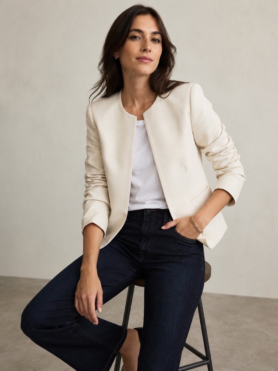 Woman in a collarless blazer with dark jeans and a tee