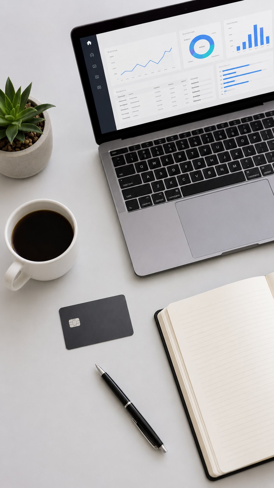 Tidy flat-lay with a card, laptop finance dashboard, notebook and coffee