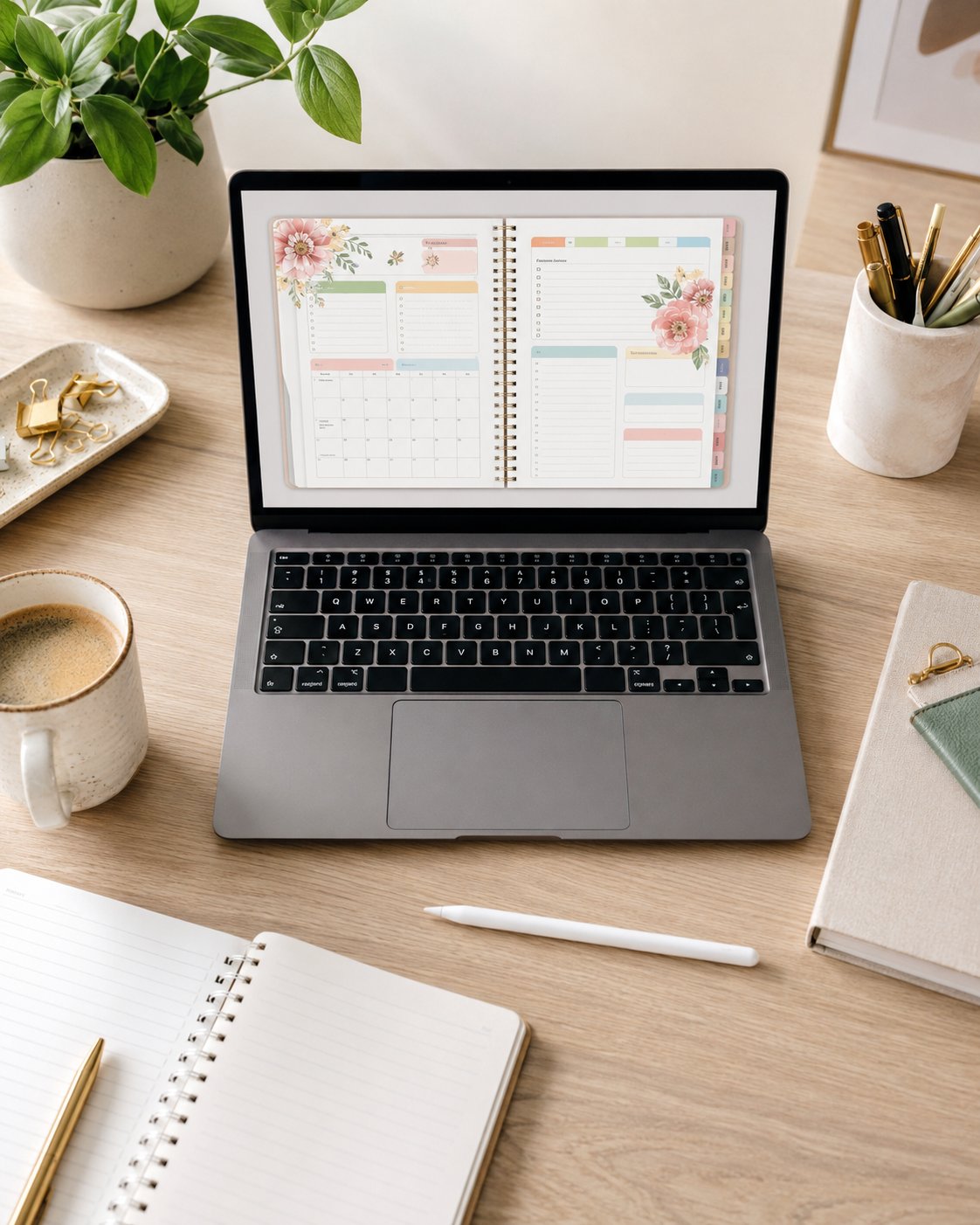 Flat-lay of a colorful printable planner design on a laptop with coffee