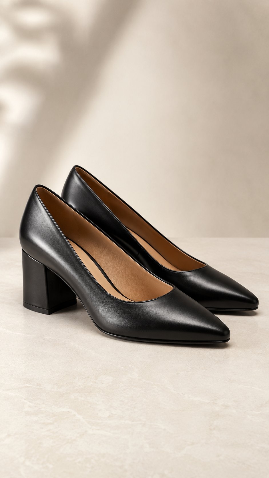 A pair of polished black leather block-heel work shoes on a clean surface